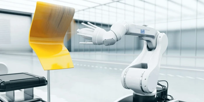 Compact white robotic arm spraying panel in a clean booth